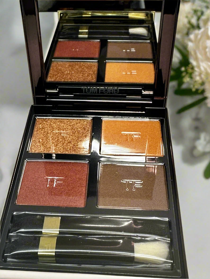 Makeup palette with various shades of eyeshadow and a brush on a white background
