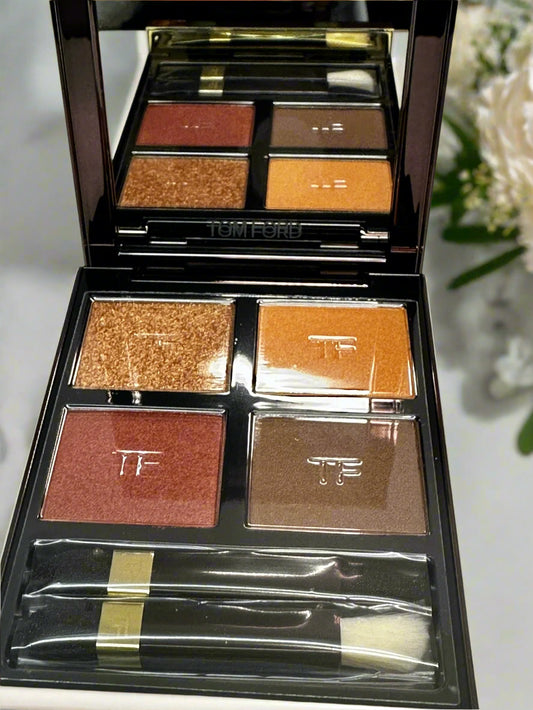 Makeup palette with various shades of eyeshadow and a brush on a white background